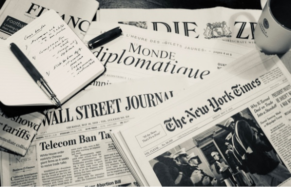 Newspapers strewn across a desk