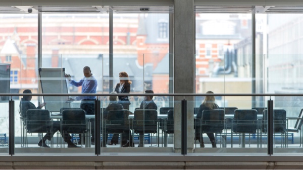 Group of employees in a meeting viewed from outside the boardroom